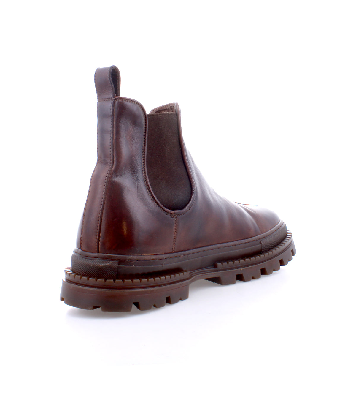 The Bed Stu Accelerate is a brown leather Chelsea boot with an elastic side panel and rugged lug outsole, featuring a chunky treaded sole, shown from the back left angle.