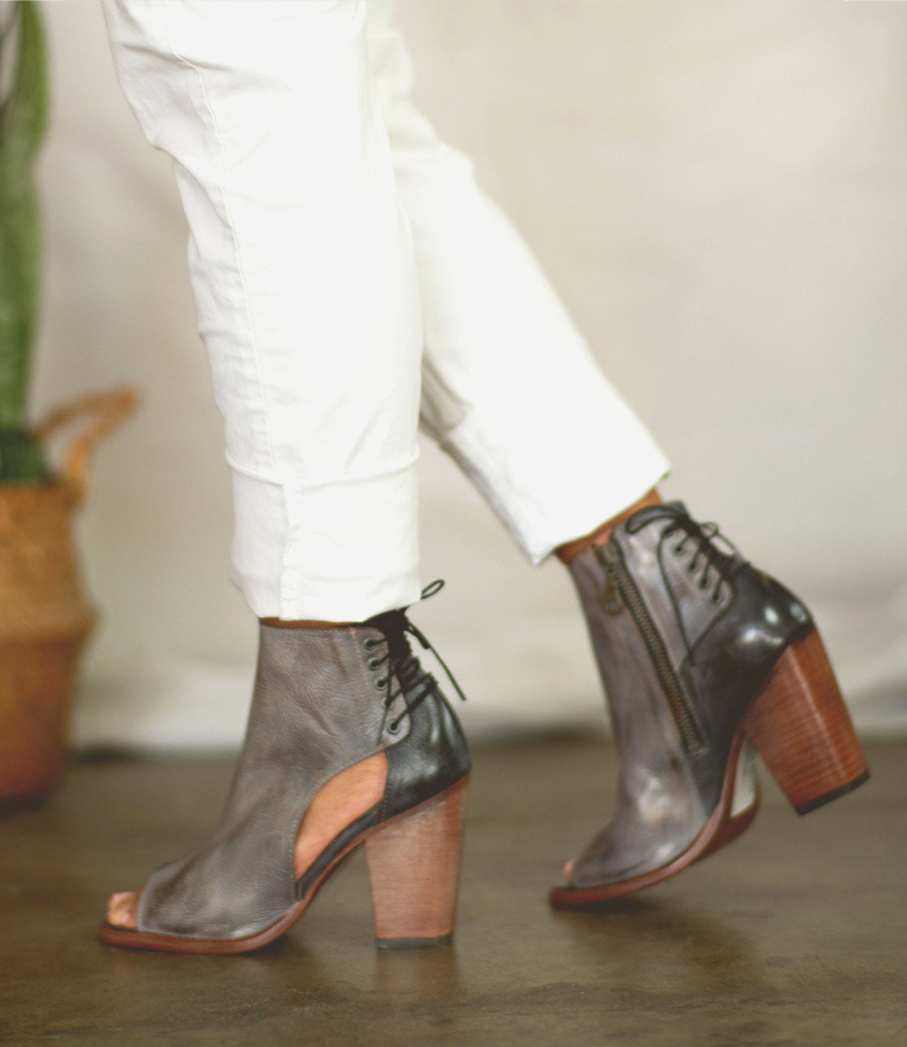 A woman wearing white pants and grey Bed Stu Angelique ankle boots.