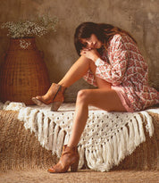 A woman is sitting wearing Angelique boots by Bed Stu.