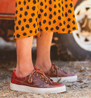A woman wearing an Azeli dress and Bed Stu sneakers.