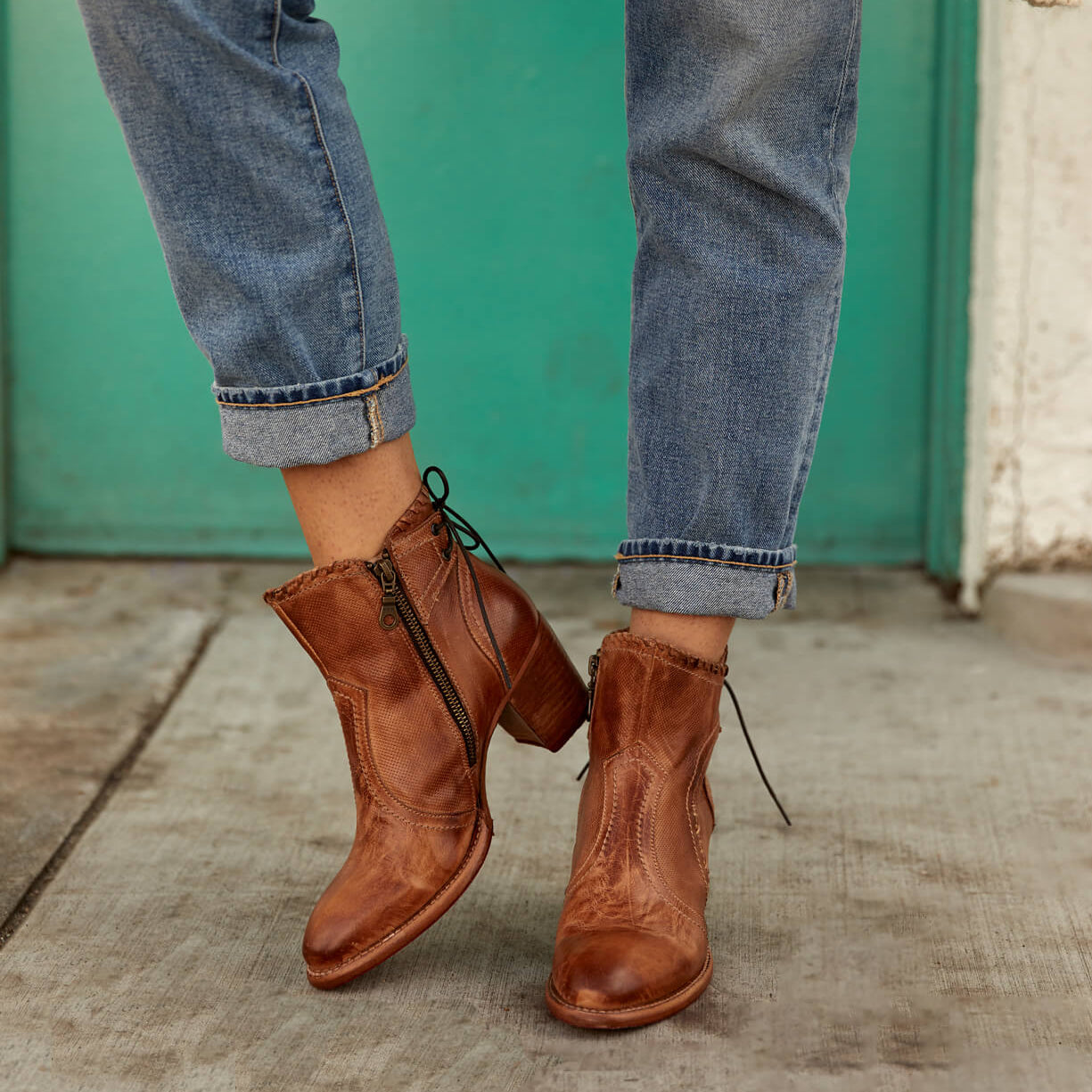 A woman wearing a pair of Bed Stu Bia boots and jeans.