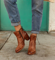 A woman wearing a pair of Bed Stu Bia boots and jeans.