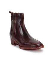 The Bed Stu Bitsy is a single brown leather ankle boot with a side zipper and a low stacked wooden heel, crafted from hand-finished leather and displayed on a white background.