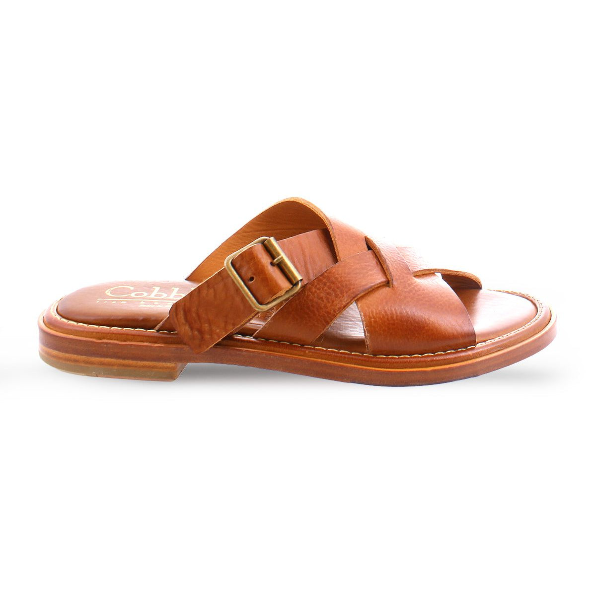 A brown slip on Italian leather sandal with a gold buckle product shot.