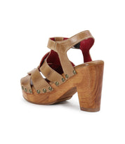 The Bed Stu Caitlin II is a brown high-heeled sandal with woven leather straps, chic stud details, and a wooden platform and heel.