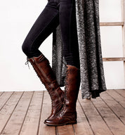 A woman is standing on a ladder in a pair of Bed Stu Della boots.