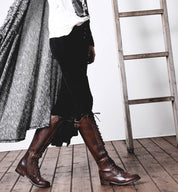 A woman is standing on a ladder in a pair of Bed Stu Della boots.