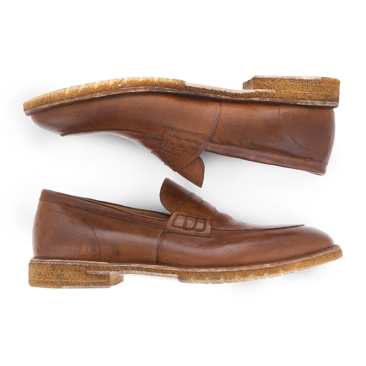 A side view of the Bed Stu Envoy loafers, featuring thick, textured soles and premium Italian leather craftsmanship, showcases one shoe placed above the other to highlight their elegant brown design.