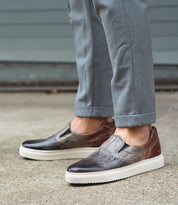 A man wearing grey pants and a pair of Bed Stu Harry slip-on shoes.