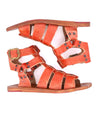 A pair of Bed Stu Hera orange sandals with buckles and straps.