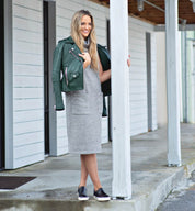 A woman wearing a Hermione gray dress and Bed Stu green jacket.