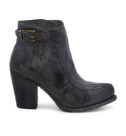 A single leather heeled ankle bootie with a vintage buckle accent against a white background. (Isla by Bed Stu)