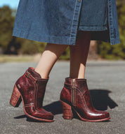 A woman wearing a Bed Stu Isla ankle boots with a denim dress.