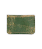 The Bed Stu Jeor is a rustic leather card holder in worn green with visible creases and scuff marks, displayed against a white background.