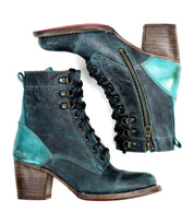 A pair of dark teal and brown leather ankle Bed Stu Judgement boots with a side zipper, 8-eye lace-up design, and low block heels, featuring a cushioned insole for added comfort.