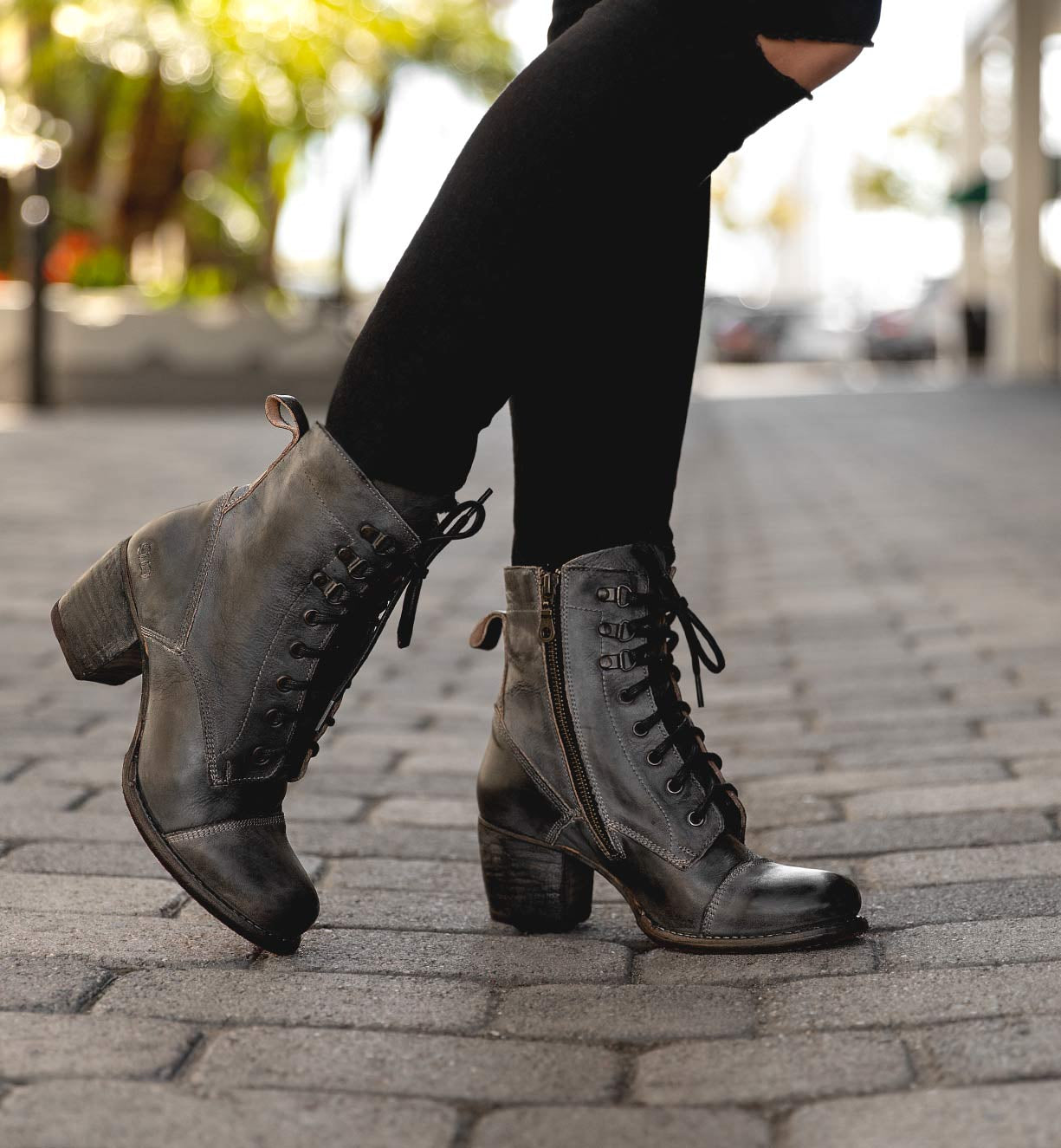A woman wearing Bed Stu Judgment boots on a sidewalk.