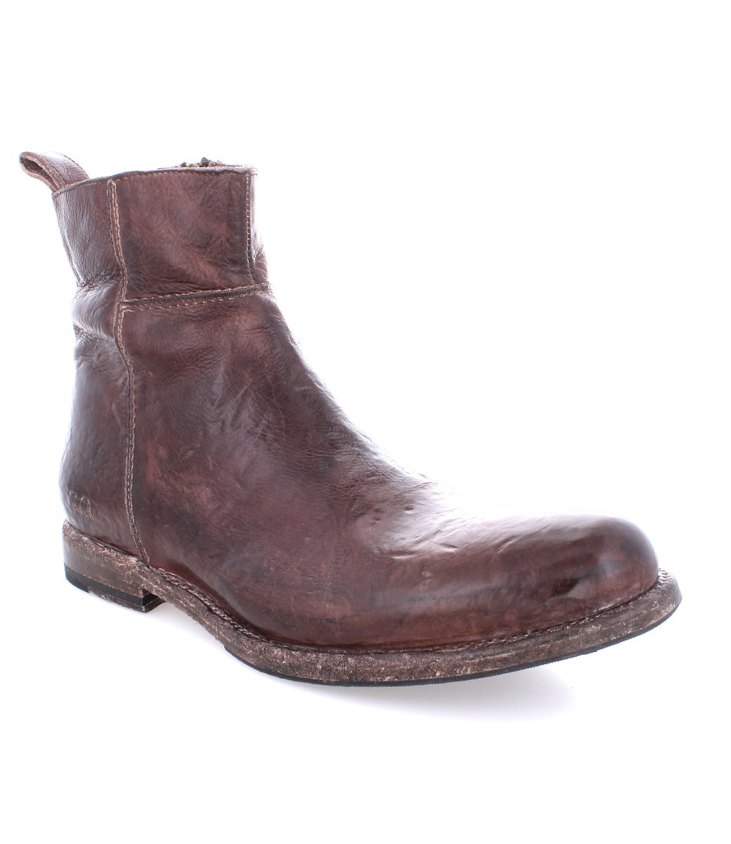 A single worn brown leather ankle boot with a distressed finish and a low heel, isolated on a white background. (Kaldi by Bed Stu)
