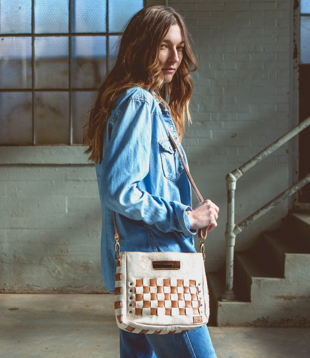 A woman wearing a denim jacket and a Bed Stu Keiki bag.