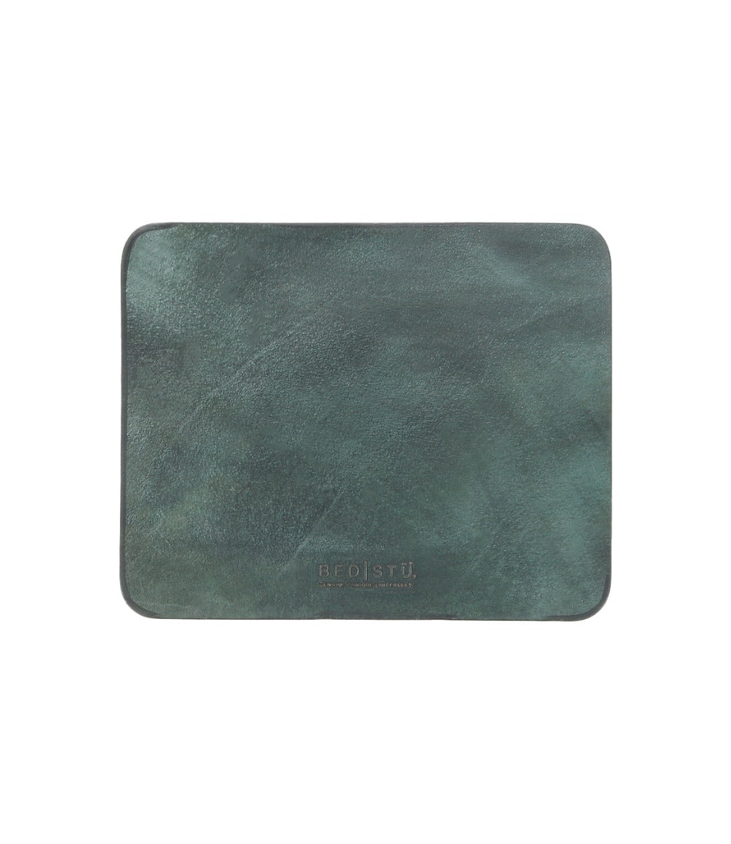 A dark green leather placemat with a smooth surface, rectangular in shape, featuring a suede underside and the brand name "Bed Stu" embossed at the bottom center. Perfect for adding elegance to your curated workspace.