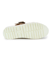 The image displays the sole of the Bed Stu Linette sandal, highlighting its white, textured, grooved XL EXTRALIGHT® outsole. It also features a brown strap with hand-woven leather detailing and a centered logo.