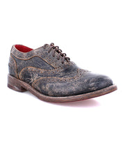 A women's distressed black wingtip oxford shoe called "Lita" by Bed Stu.