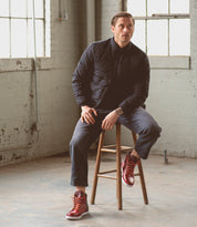 A man sitting on a Lordmind stool in a warehouse.