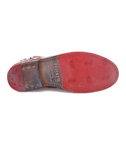 A pair of Lotus shoes with a red leather sole by Bed Stu.