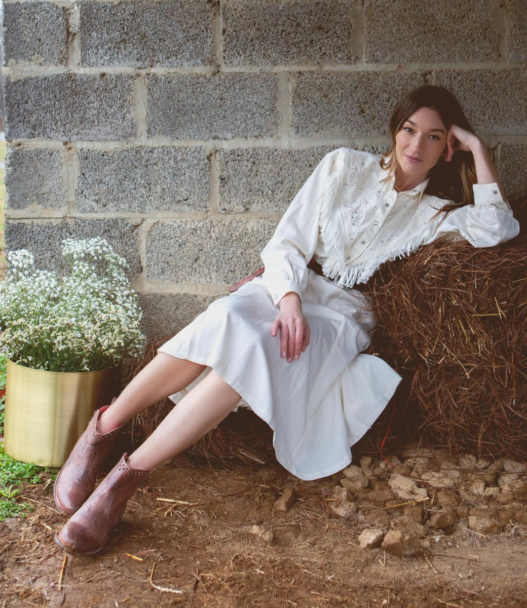 A woman in a white dress wearing Bed Stu's Lotus boot.