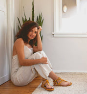A woman sitting on the floor in a room with a Moon potted plant from Bed Stu.