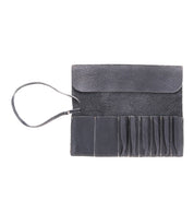 An open black leather Prepped Leather Wrap from Bed Stu, featuring multiple compartments and an attached strap, designed to hold small tools, artist tools, or accessories.