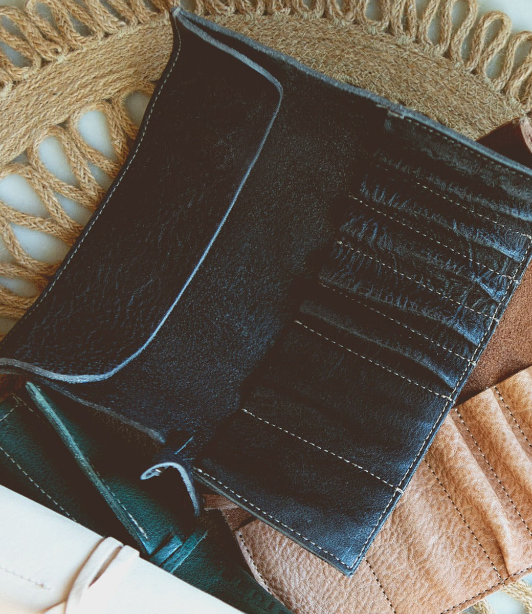 A Prepped leather wallet sitting on a wicker basket.