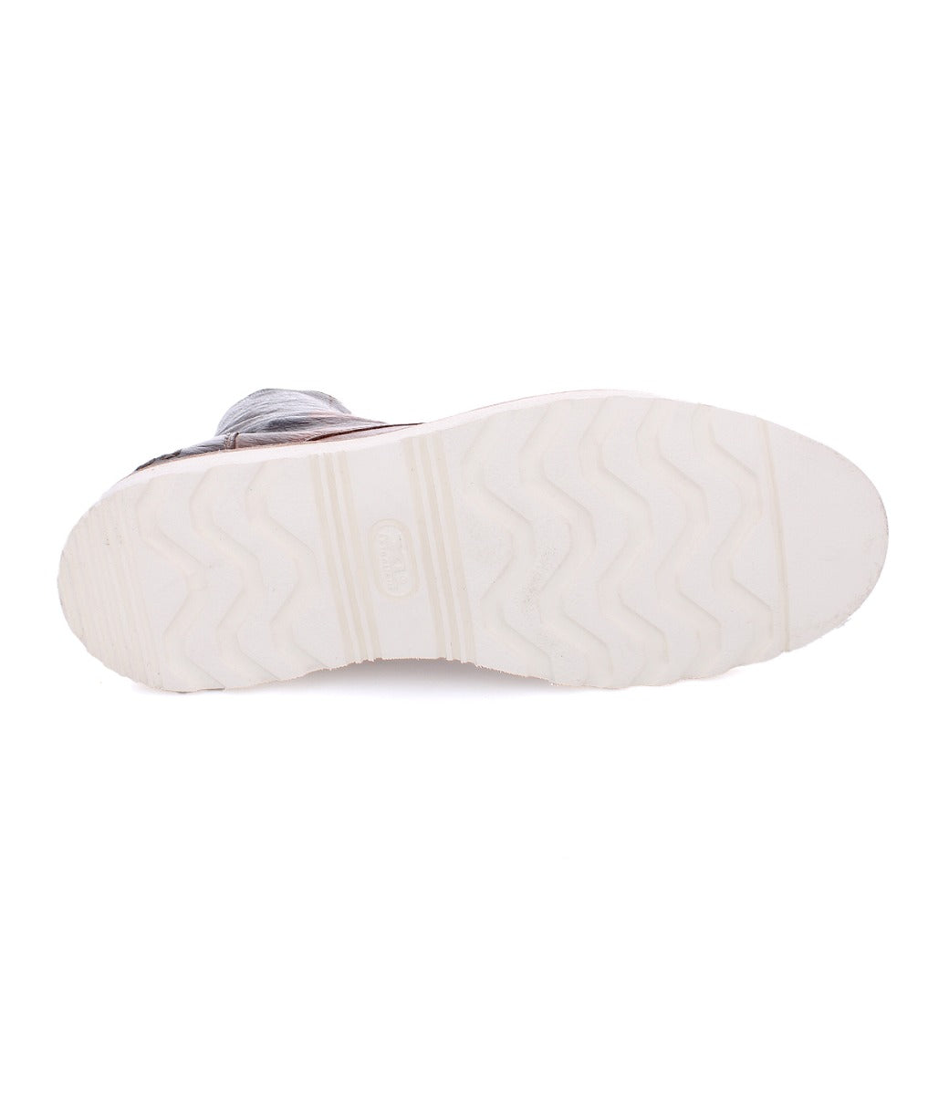 The sole of a Protege Light sneaker by Bed Stu, with wavy tread patterns and a visible brand logo, featuring cushioned leather insoles.