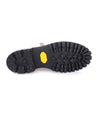 Bottom view of a rugged two-tone Protege Trek boot sole with distinct tread pattern and a yellow Bed Stu logo, isolated on a white background.