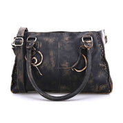 The Bed Stu Rockababy is a weathered black leather handbag with two handles and an adjustable shoulder strap, featuring decorative stitching along the edges—this everyday bag is a compact option for any occasion.