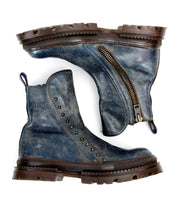 The Bed Stu Tanto boots for men feature worn blue leather, chunky brown soles, a side zipper, and decorative metal studs on the outer side—shown from both top and side views for European-inspired style.