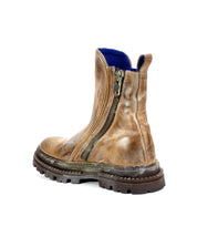 The Bed Stu Tanto is a single brown men’s boot with a rugged lug outsole and side zipper, shown on a plain white background, radiating subtle European flair.