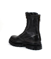 The Bed Stu Tempt is a black leather lace-up combat boot featuring a chunky sole, Chelsea boot influences, and a vertical back zipper—a stylish hybrid enhancement for any wardrobe.