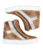 The Bed Stu Twist is a pair of brown and white high-top sneakers featuring leather panels, side zippers, and white rubber soles, shown on a white background.