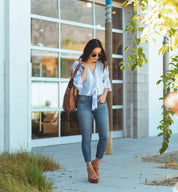 A woman wearing jeans holding an Amelie bag by Bed Stu.