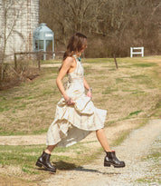 A woman in a Valda Hi dress by Bed Stu walking down a dirt road.