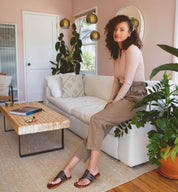 A woman's wearing black Yoli sandals by Bed Stu.