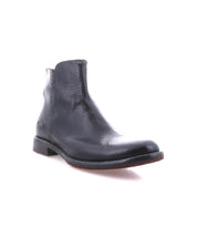 The Bed Stu Yurisa is a black leather ankle boot with a low heel, red leather lining, and side zipper—shown on a white background as the perfect everyday boot.