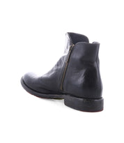 The Bed Stu Yurisa is a black leather ankle boot with a side zipper and red lining, shown from the back and slightly to the side on a white background—perfect for everyday wear.