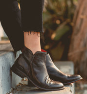 A woman wearing the Yurisa black leather chelsea boots by Bed Stu.