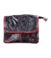 The Bed Stu Ziggy is a dark brown classic leather crossbody with a fold-over flap and red accents, offering hands-free convenience.
