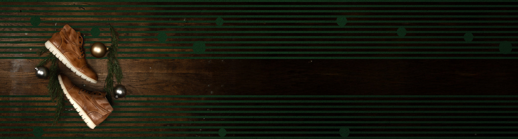 Brown leather shoes and three Christmas ornaments on a wooden surface with green striped patterns.