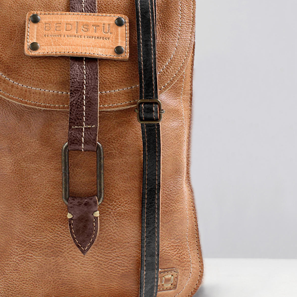 Close-up of the Studio Thin Shoulder Strap by Bed Stu, featuring a brown leather design with a buckle and black edge trim. This stylish strap allows you to showcase your own style and creativity.