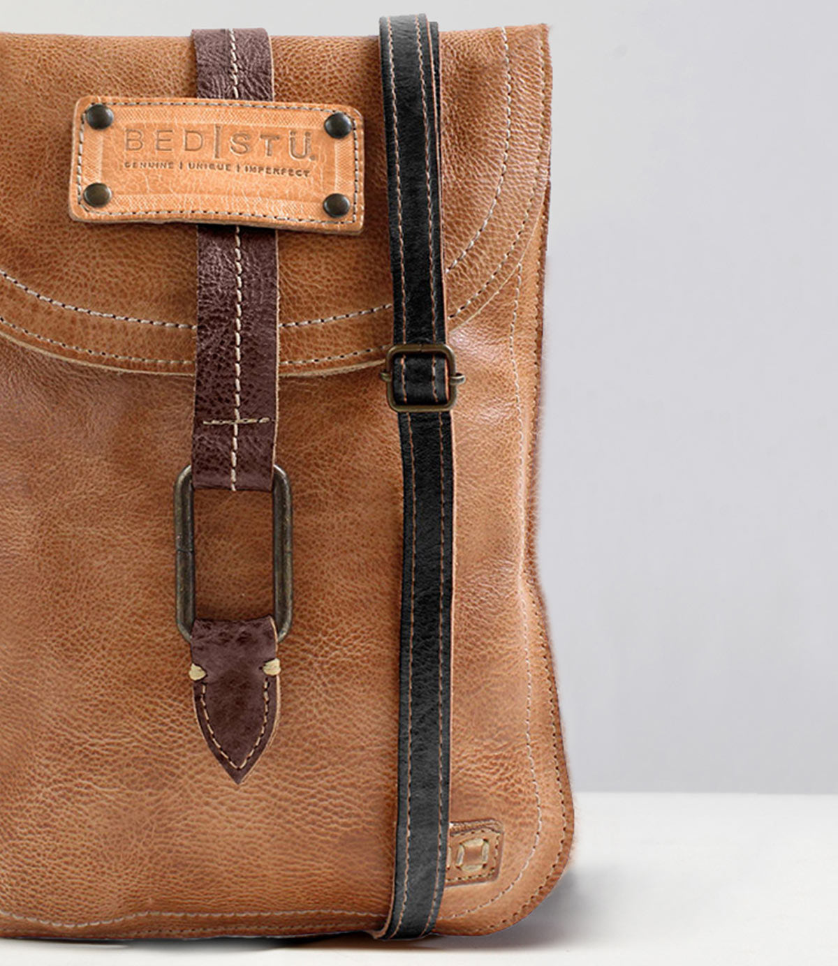 Close-up of the Studio Thin Shoulder Strap by Bed Stu, featuring a brown leather design with a buckle and black edge trim. This stylish strap allows you to showcase your own style and creativity.