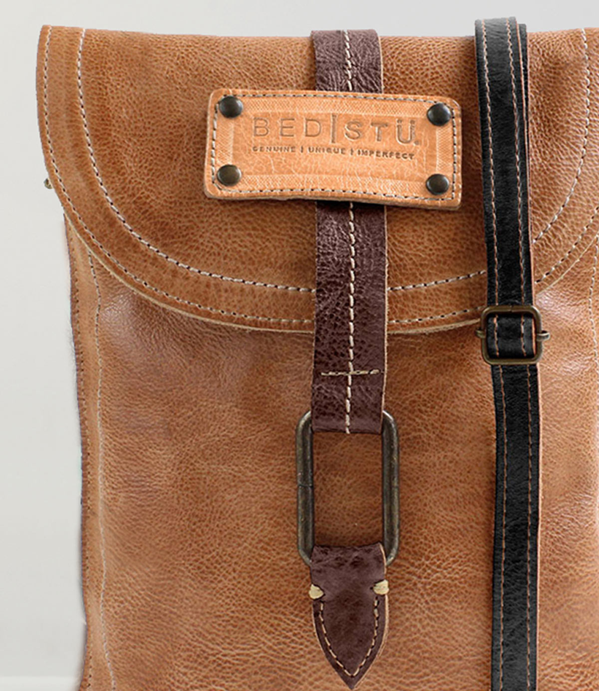 Close-up of a brown leather Bed Stu Studio Ring Strap backpack featuring a front buckle strap and stitching details, showcasing the creativity that goes into crafting such a personalized bag.