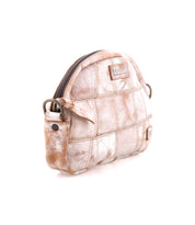The Bed Stu Abundance is a small, dome-shaped sling bag with light brown and white patchwork and checkered patterns, a side pocket, zipper closure, and metal hardware for easy hands-free use.